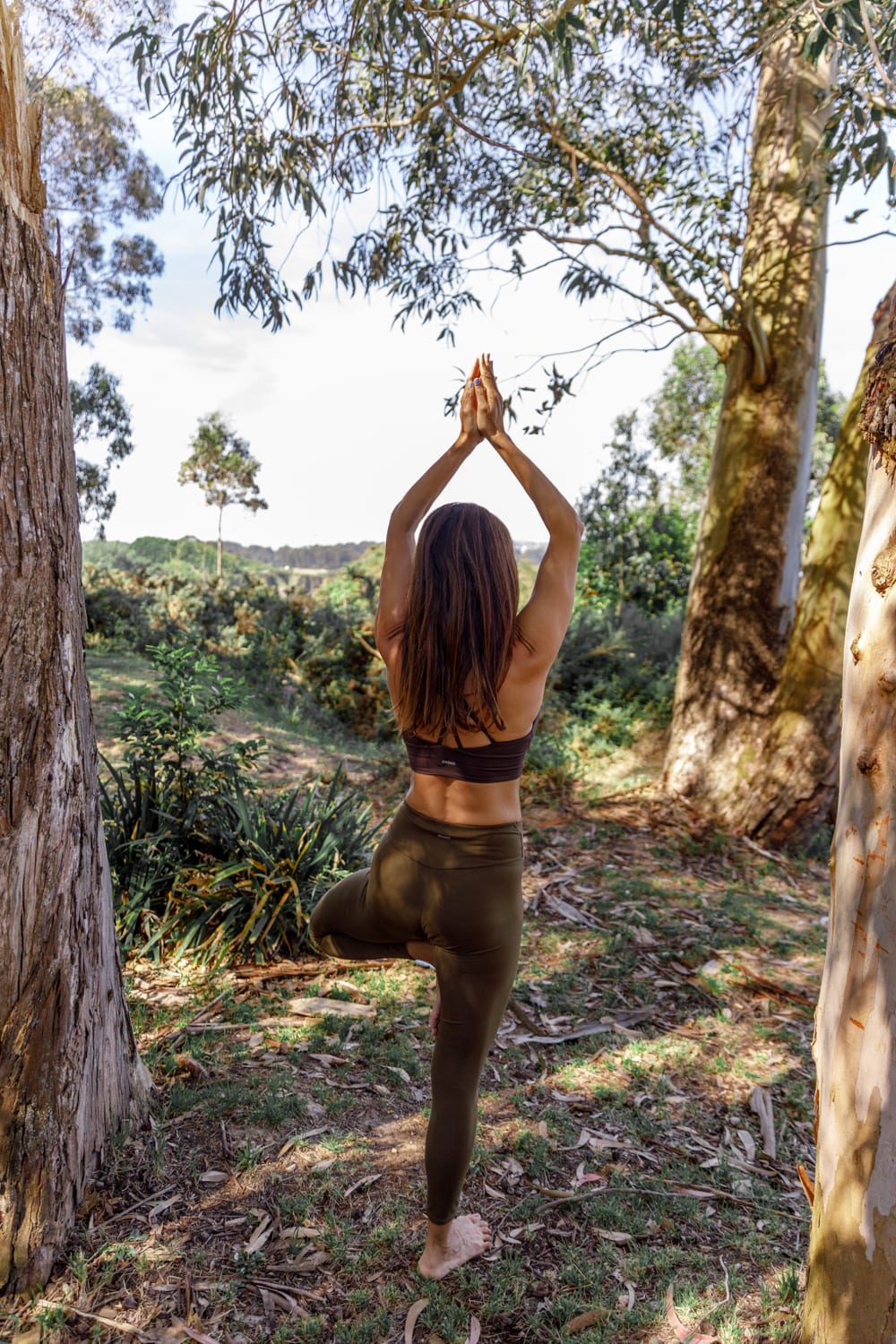 Fernanda practicando yoga entre árboles